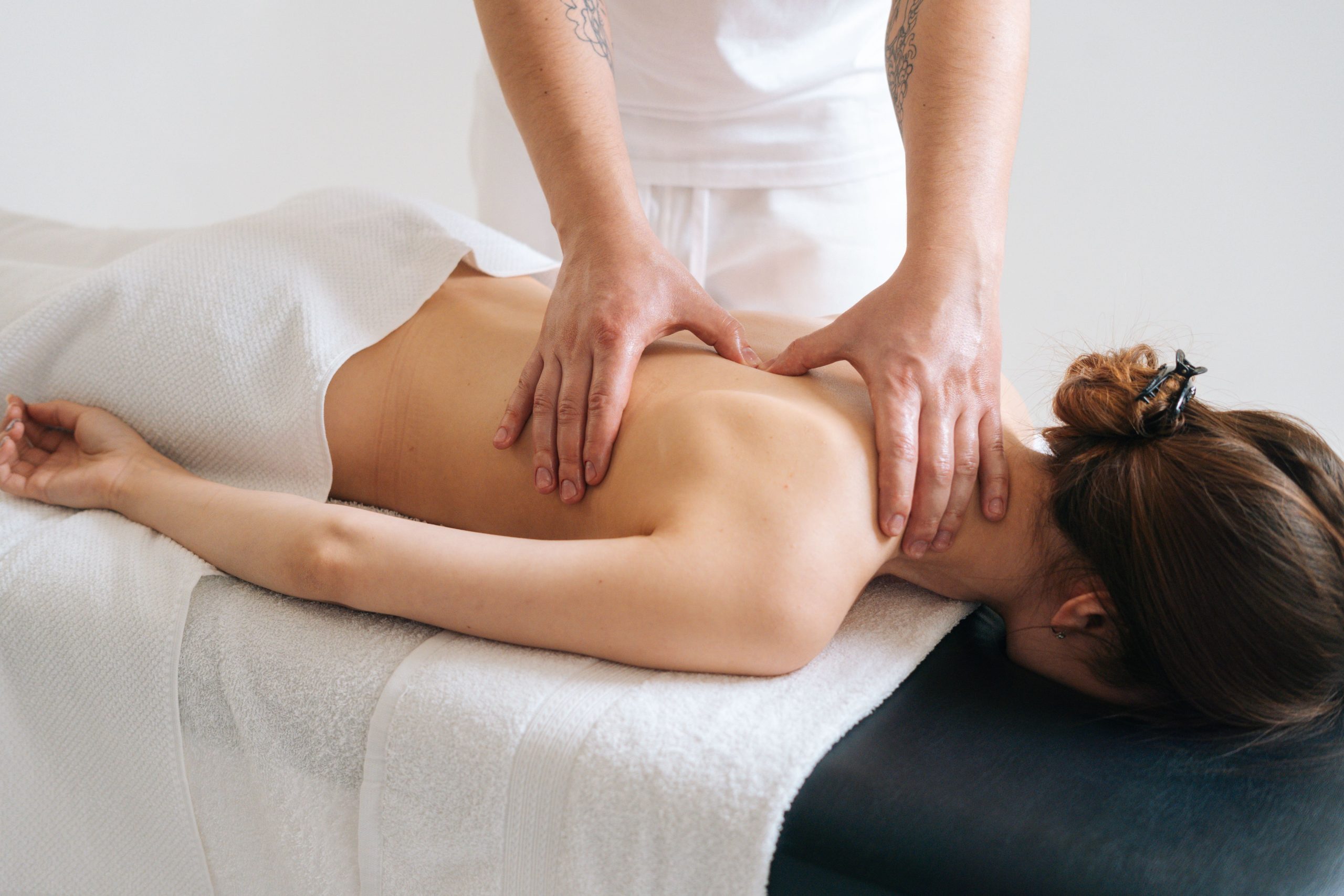 Male,Masseur,Massaging,Back,And,Shoulder,Blades,Of,Young,Woman